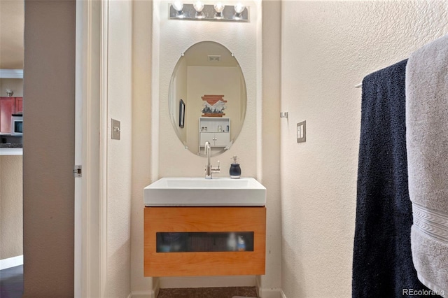 bathroom with vanity and a textured wall