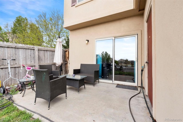 view of patio featuring an outdoor hangout area and fence