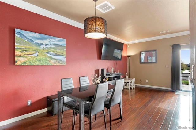 dining space with ornamental molding, baseboards, visible vents, and wood finished floors