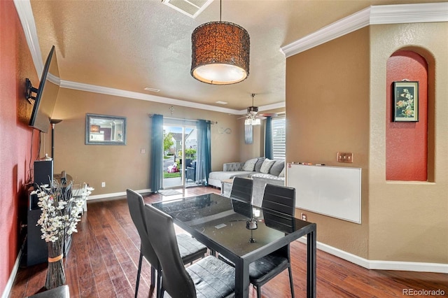 dining space featuring visible vents, crown molding, ceiling fan, dark wood-style floors, and baseboards
