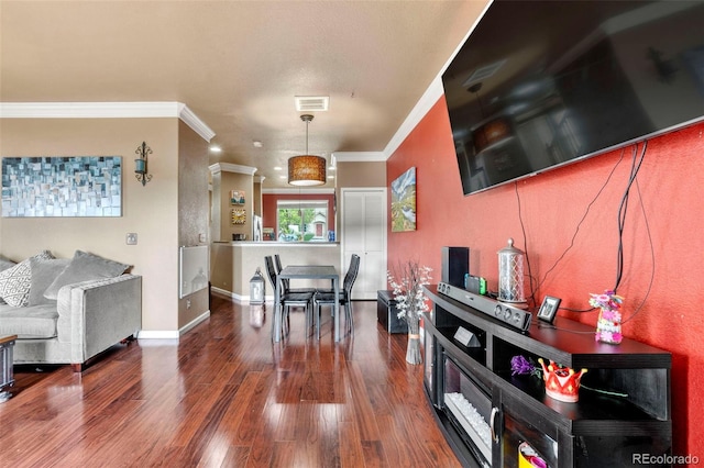 dining area featuring baseboards, crown molding, visible vents, and wood finished floors