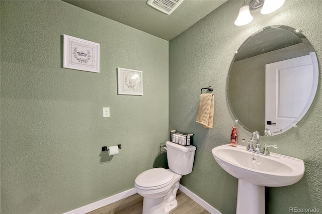 bathroom with toilet and hardwood / wood-style floors