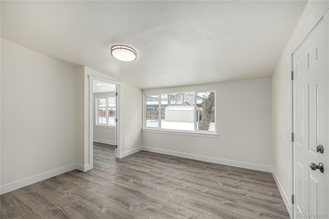 unfurnished bedroom with lofted ceiling and light hardwood / wood-style floors