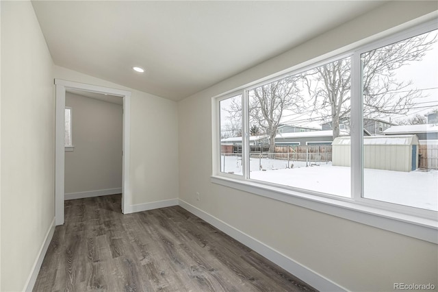 empty room featuring dark wood-type flooring and vaulted ceiling