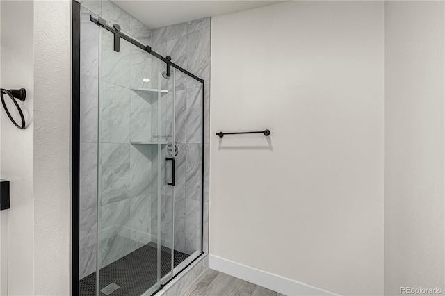 bathroom featuring hardwood / wood-style flooring and a shower with shower door