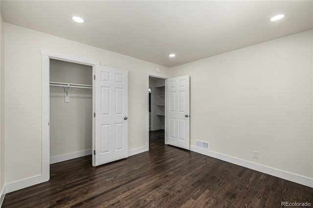 unfurnished bedroom featuring dark hardwood / wood-style flooring and a closet