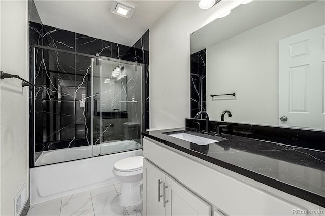 full bathroom with vanity, bath / shower combo with glass door, and toilet