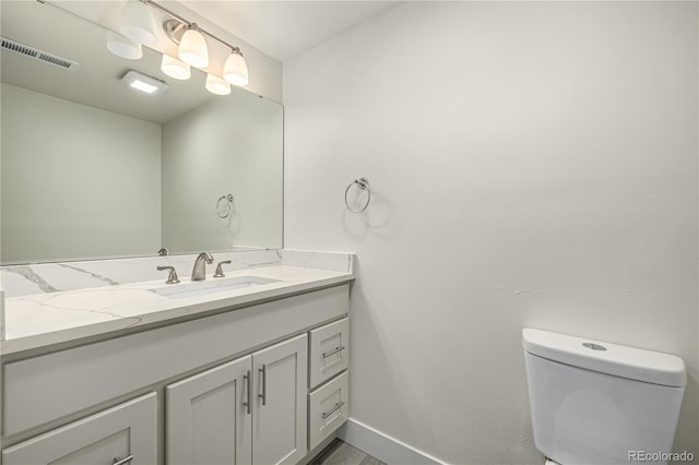 bathroom featuring vanity and toilet