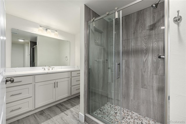 bathroom with vanity, wood-type flooring, and walk in shower