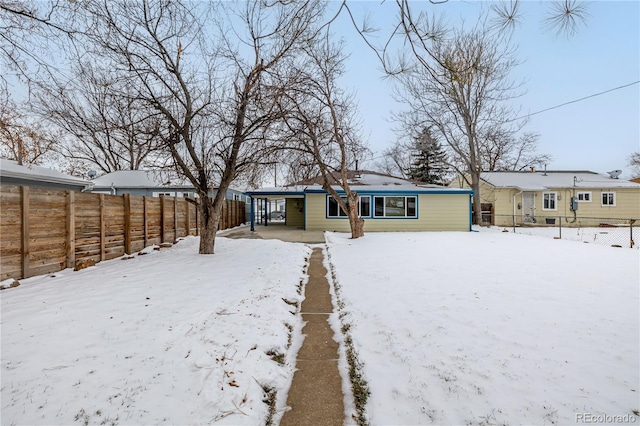 view of snow covered back of property