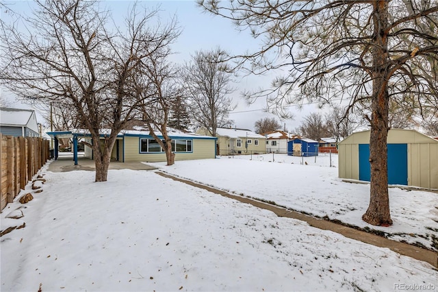 yard covered in snow featuring a storage shed