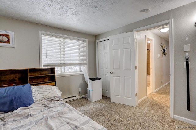 bedroom with a baseboard radiator, light colored carpet, a closet, and a textured ceiling