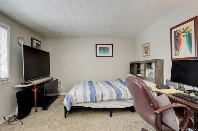 bedroom with light colored carpet and a textured ceiling