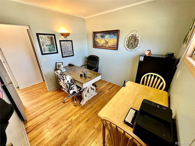 home office with ornamental molding, light wood-type flooring, and baseboards