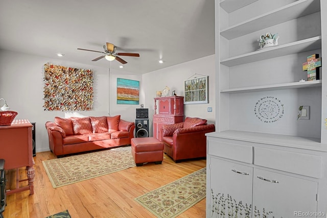 living room featuring light wood-style floors, ceiling fan, built in features, and recessed lighting