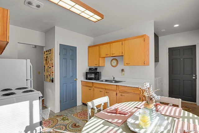 kitchen featuring white appliances, visible vents, light countertops, washer and dryer, and a sink