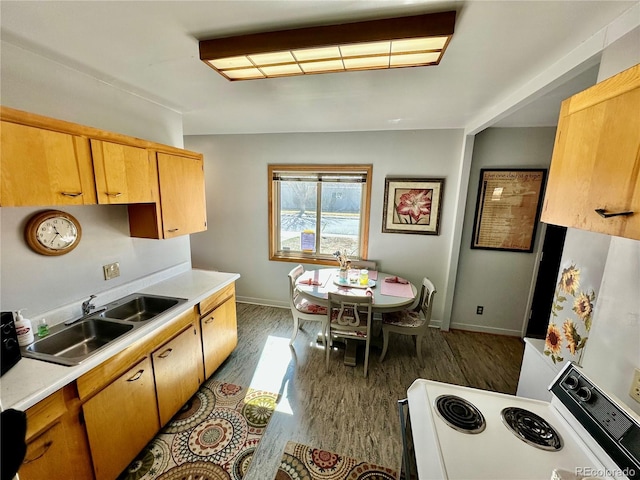 kitchen with white range with electric stovetop, baseboards, light countertops, and a sink