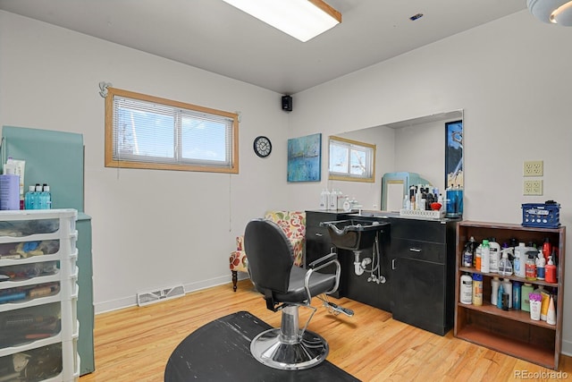 home office featuring light wood finished floors, visible vents, and baseboards