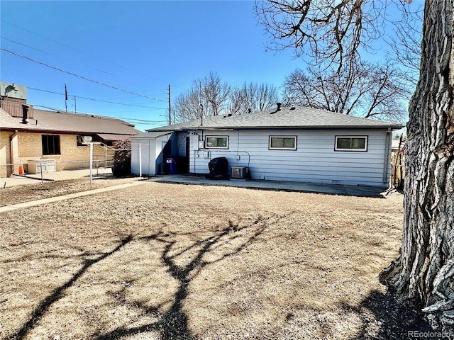 ranch-style home featuring a storage unit, fence, and an outbuilding