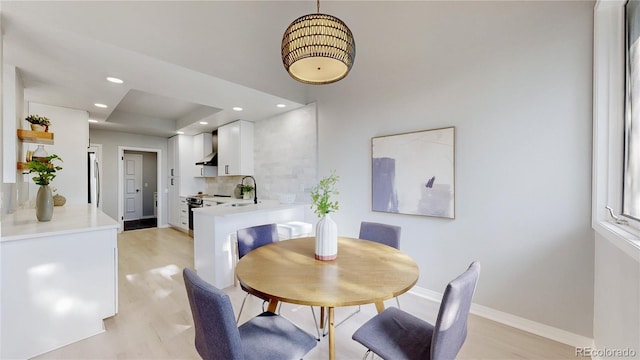 dining area featuring light wood-style floors, baseboards, and recessed lighting