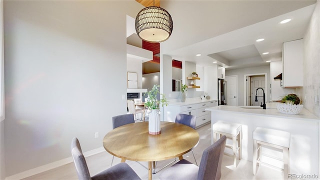 dining room with recessed lighting, a high ceiling, and baseboards