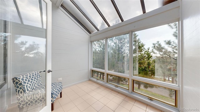 sunroom featuring tile patterned floors and vaulted ceiling