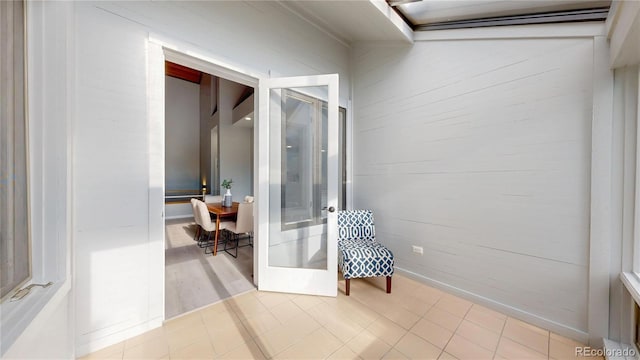 hallway featuring wooden walls and tile patterned floors