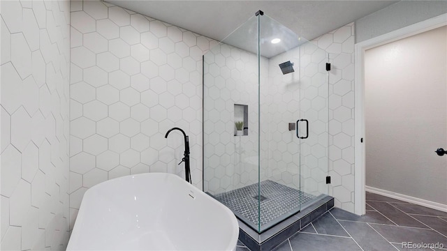 bathroom with a stall shower, a freestanding bath, tile patterned floors, recessed lighting, and baseboards