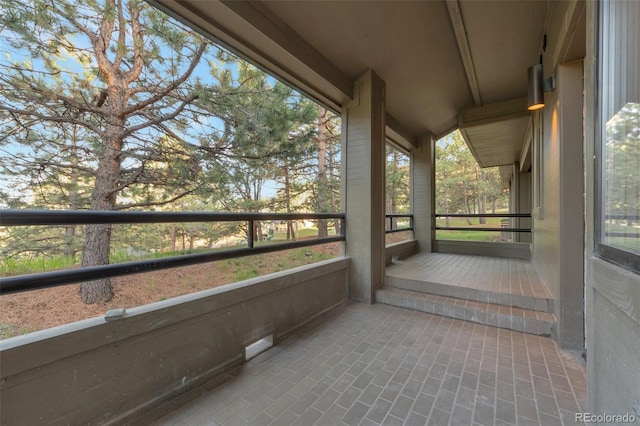 unfurnished sunroom featuring vaulted ceiling