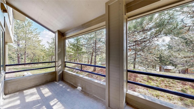 unfurnished sunroom with view of scattered trees