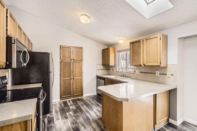 kitchen with sink, decorative backsplash, dark hardwood / wood-style floors, appliances with stainless steel finishes, and kitchen peninsula