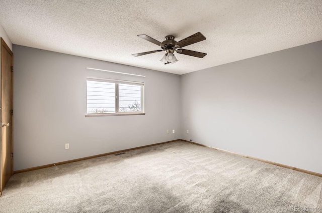 empty room featuring carpet, ceiling fan, and a textured ceiling