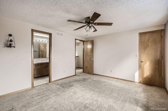 unfurnished bedroom featuring a textured ceiling, ceiling fan, light carpet, and connected bathroom