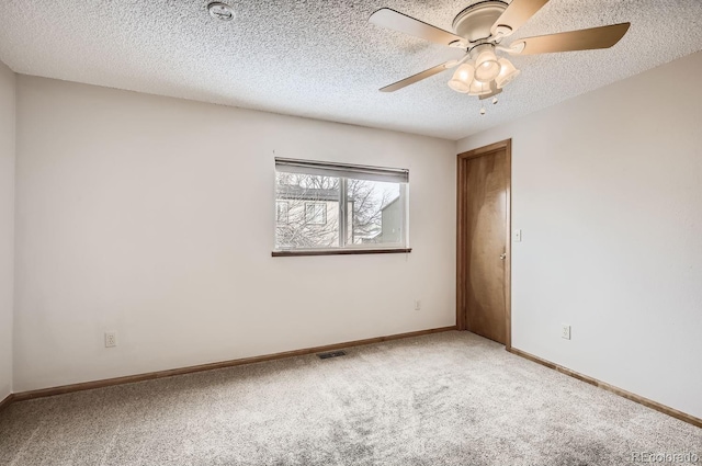 carpeted empty room featuring ceiling fan and a textured ceiling