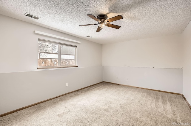 empty room with carpet flooring, ceiling fan, and a textured ceiling