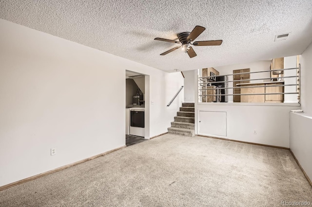 interior space with carpet, ceiling fan, a textured ceiling, and washer / clothes dryer