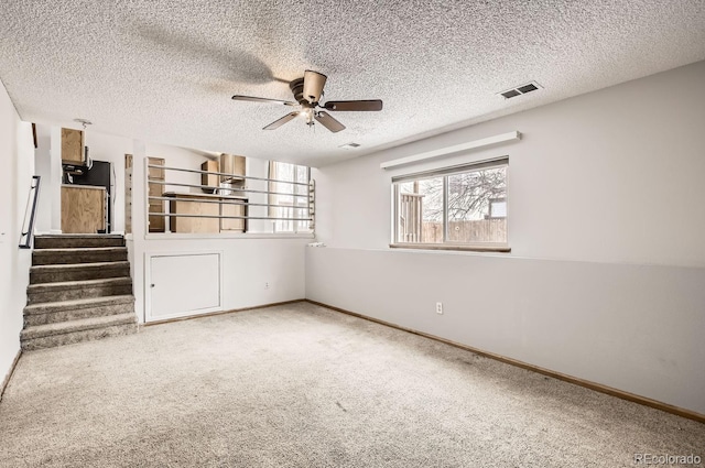 spare room featuring carpet, a textured ceiling, and ceiling fan