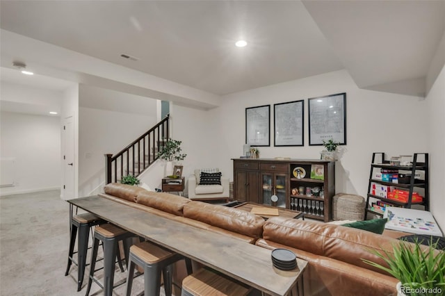 living area with recessed lighting, visible vents, stairs, and light colored carpet