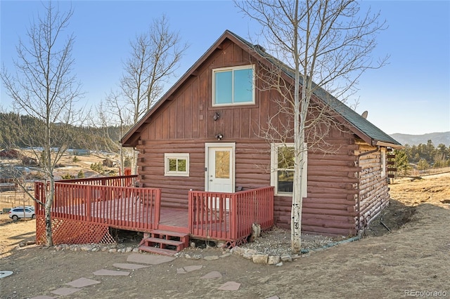 rear view of house with a deck with mountain view