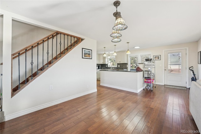 unfurnished living room with dark hardwood / wood-style floors and a chandelier