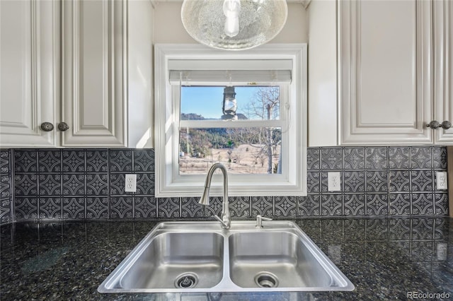 kitchen with sink, white cabinetry, dark stone counters, and tasteful backsplash