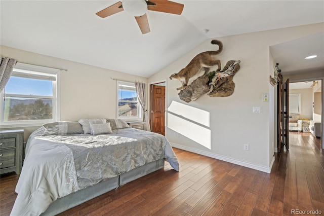 bedroom featuring lofted ceiling, multiple windows, dark hardwood / wood-style flooring, ceiling fan, and a barn door