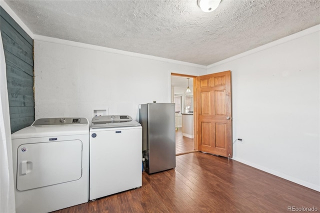 washroom with washing machine and dryer, ornamental molding, dark wood-type flooring, and a textured ceiling