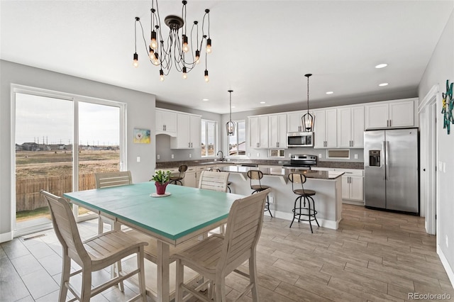 dining room featuring visible vents, a chandelier, baseboards, recessed lighting, and light wood-type flooring