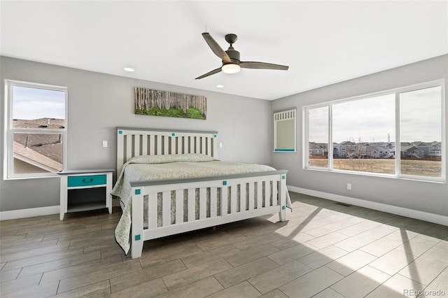 bedroom featuring baseboards, multiple windows, and wood finished floors