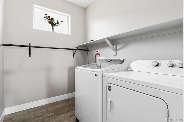 washroom featuring baseboards, washing machine and clothes dryer, laundry area, and wood finish floors