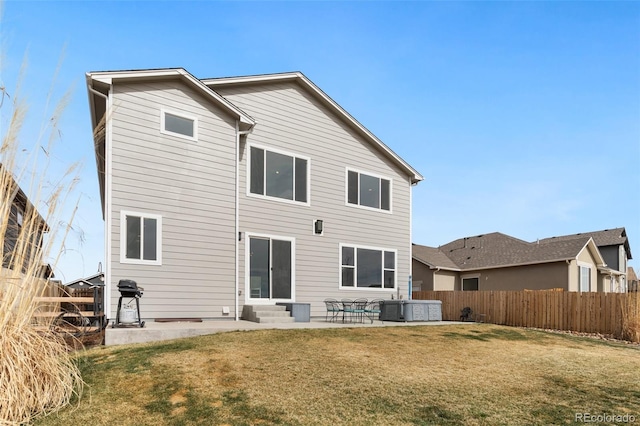 rear view of property featuring a lawn, fence, entry steps, and a patio area