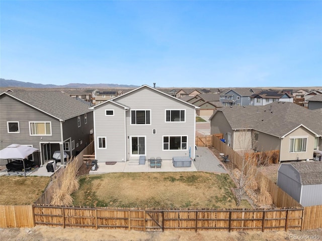 rear view of house featuring a fenced backyard, a residential view, entry steps, and a patio