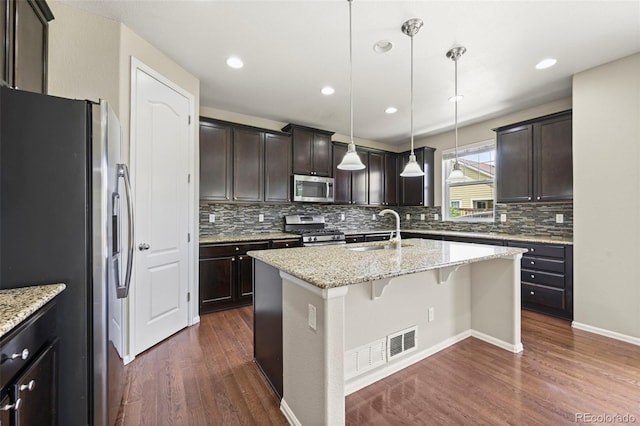19659 W 59th Dr, Golden, CO 80403 - kitchen featuring stainless steel appliances, dark wood-type flooring, a kitchen island with sink, backsplash, and recessed lighting