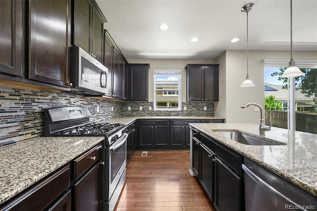 19659 W 59th Dr, Golden, CO 80403 - kitchen with stainless steel appliances, dark wood-type flooring, light stone countertops, decorative backsplash, and recessed lighting